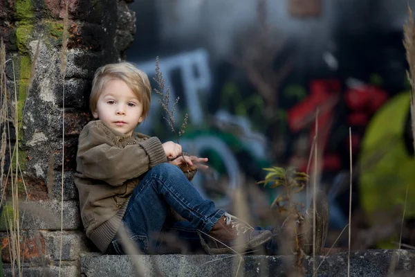 Bambino Carino Posa Una Casa Mattoni Rovina Seduto Uno Scudo — Foto Stock