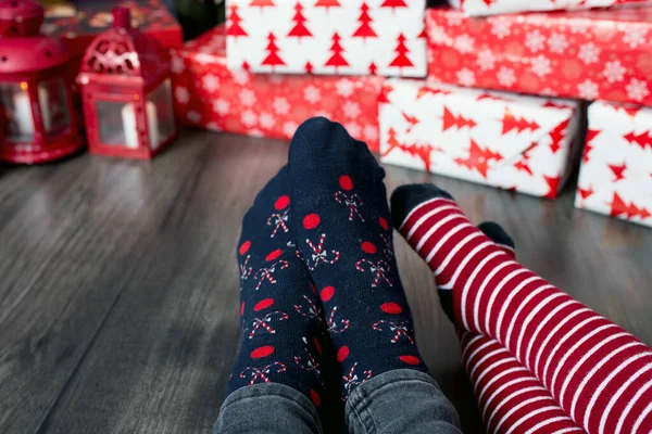 脚穿着圣诞袜在格子布上 母亲和孩子坐在一起准备礼物 人们在家里放松 — 图库照片