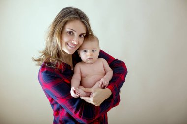 Onun yeni doğan bebek çocuk okşama, onun kollarında etrafında ve mutluluktan gülümseyen genç anne,