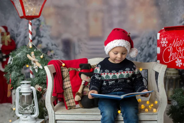 Gyönyörű Gyermek Szőke Kisgyerek Könyvet Olvas Egy Padon Karácsonyi Dekorációval — Stock Fotó