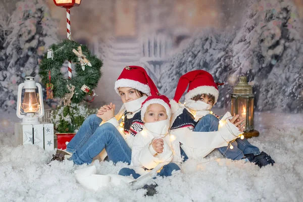 Dzieci Siedzące Śniegu Owinięte Papier Toaletowy Świąteczne Sznurki Świetlne Patrzące — Zdjęcie stockowe
