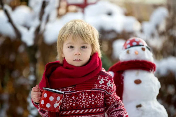 甘いブロンドの幼児の子供 男の子 雪と庭で遊ぶ 雪だるまを作る 幸せな子供の冬の時間屋外 — ストック写真