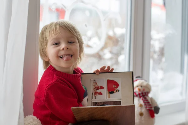 Söt Blond Småbarn Sitter Fönstret Tittar Snön Faller Utanför Läser — Stockfoto