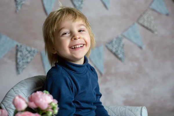 かわいい金髪の幼児の子供 男の子 小さな赤ちゃんの肘掛け椅子に座って 本を読んで花を持って スタジオ室内で撮影 — ストック写真