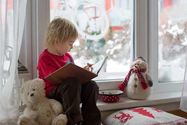 Söt Blond Småbarn Sitter Fönstret Tittar Snön Faller Utanför Läser — Stockfoto