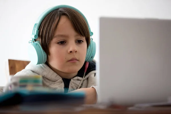 Criança Escolar Sentada Mesa Com Laptop Escrevendo Tarefas Escolares Enquanto — Fotografia de Stock