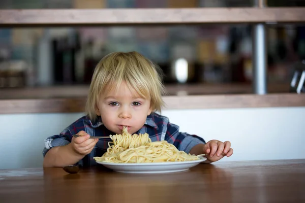 小男孩 蹒跚学步的孩子 午餐吃意大利面 和喂养泰迪熊的朋友 桌上放着意大利面和西红柿的锅 — 图库照片