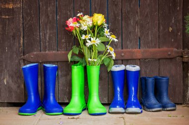 Bahçede güzel çiçekli lastik botlar.