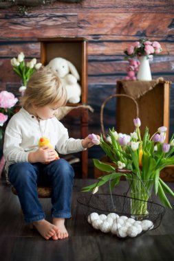 Küçük tatlı sarışın çocuk, stüdyoda paskalya süslemesi olan çocuk.
