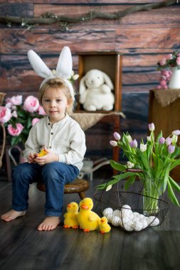Küçük tatlı sarışın çocuk, stüdyoda paskalya süslemesi olan çocuk.