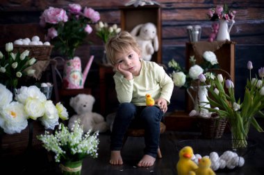 Küçük tatlı sarışın çocuk, stüdyoda paskalya süslemesi olan çocuk.