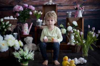 Küçük tatlı sarışın çocuk, stüdyoda paskalya süslemesi olan çocuk.