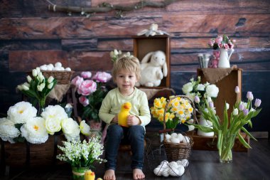 Küçük tatlı sarışın çocuk, stüdyoda paskalya süslemesi olan çocuk.