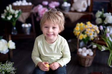 Küçük tatlı sarışın çocuk, stüdyoda paskalya süslemesi olan çocuk.