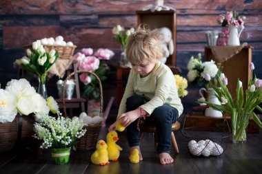 Küçük tatlı sarışın çocuk, stüdyoda paskalya süslemesi olan çocuk.