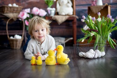Küçük tatlı sarışın çocuk, stüdyoda paskalya süslemesi olan çocuk.