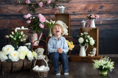 Küçük tatlı sarışın çocuk, stüdyoda paskalya süslemesi olan çocuk.