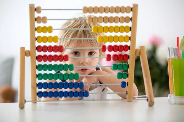 甘いです幼児子供 ブロンド少年 家で数学を学びますカラフルなそろばん付き 新鮮に作られたジュースを飲みます — ストック写真