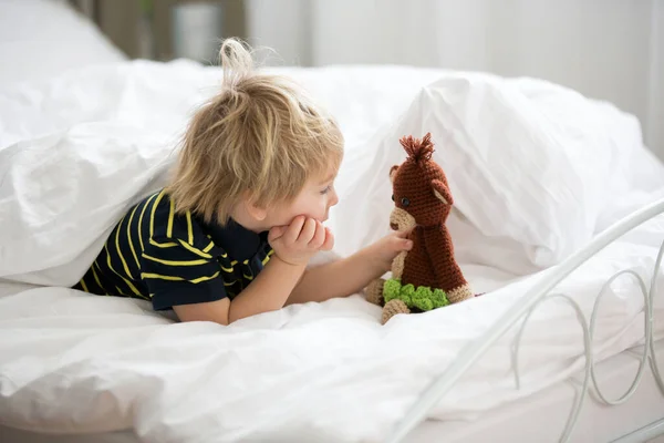 ブロンドの幼児の子供はベッドでぬいぐるみ猿と遊び 夏に遊ぶ — ストック写真