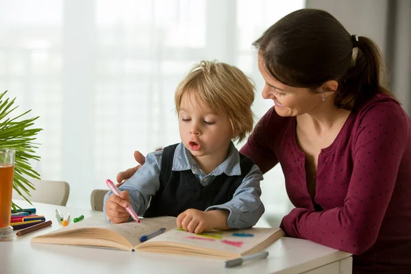 可爱的学龄前孩子 金发男孩 在作业本上填写一些作业 妈妈在家里帮他 — 图库照片