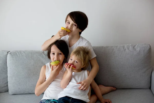 Tres Niños Hermanos Varones Hermanos Comiendo Rosquillas Colores Casa Sofá —  Fotos de Stock