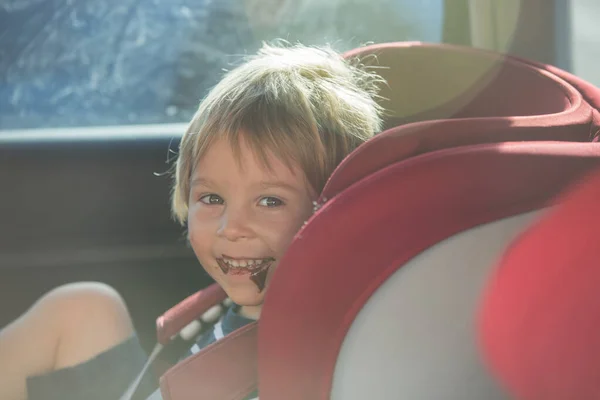 Παιδί Νήπιο Αγόρι Κάθεται Στο Κάθισμα Του Αυτοκινήτου Τρώει Σοκολάτα — Φωτογραφία Αρχείου