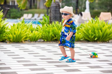 Mauritius 'ta yaz tatili tatil köyünde küçük sevimli bir çocuk, günlük giyinmiş, güneş gözlüğü takıyordu.