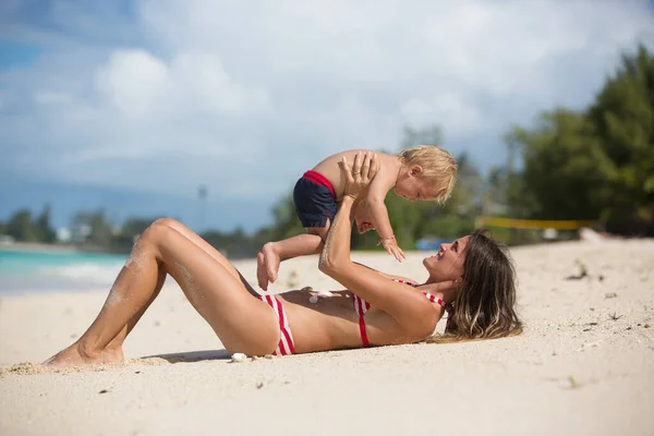 妈妈和孩子在热带海滩玩耍 家庭海洋暑假 妈妈和孩子 蹒跚学步的孩子 在水里玩 对父母和孩子来说 海洋和水都很有趣 健康舒适的家庭在异国情调的海滩 — 图库照片