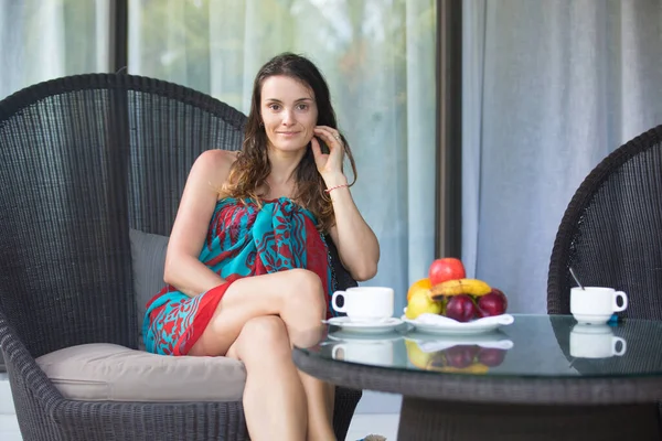 一个美丽的年轻女子的画像 暑假在后廊边喝咖啡 桌上放水果 — 图库照片