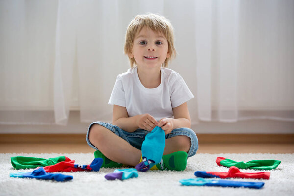 Child feet with different socks standing in rows, kids wearing different colorful socks