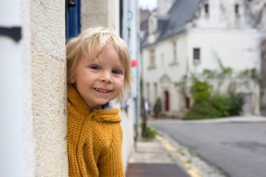 Çocuk, çocuk bulutlu bir günde Fransa 'nın güzel küçük bir köyünde yürüyor.