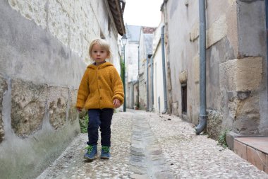 Çocuk, çocuk bulutlu bir günde Fransa 'nın güzel küçük bir köyünde yürüyor.