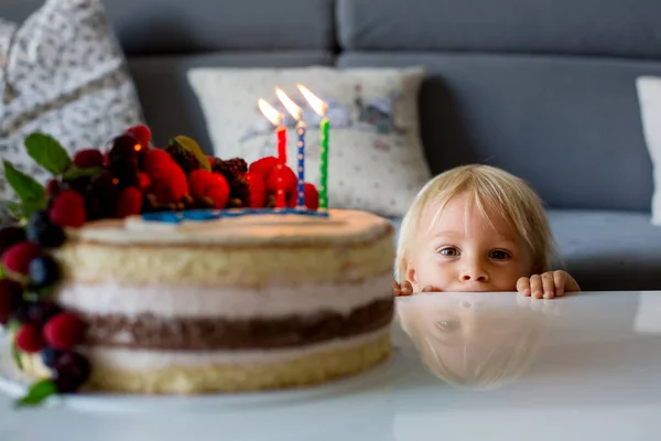 青いシャツの美しい3歳の幼児の少年は 彼の誕生日を祝い 自家製の焼きケーキにキャンドルを吹いて 子供のための誕生日パーティー — ストック写真