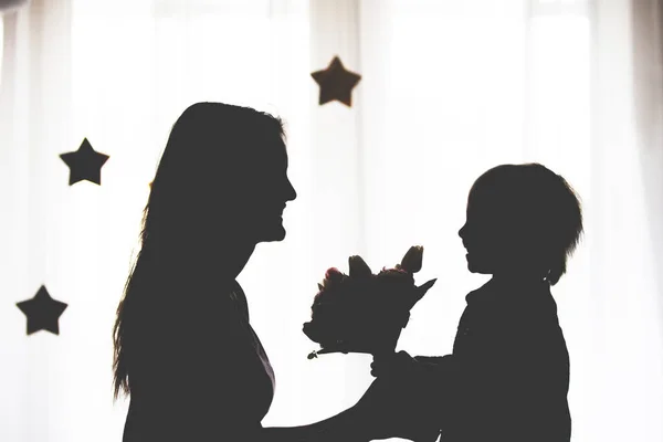 Silhueta Mãe Feliz Segurando Menino Mãos Isolado Branco — Fotografia de Stock