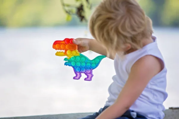 Criança Pequena Menino Loiro Brincando Com Pop Brinquedo Stress Parque — Fotografia de Stock