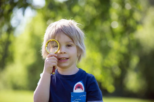 可爱的幼儿 金发男孩 玩放大镜 在公园里画画册 — 图库照片