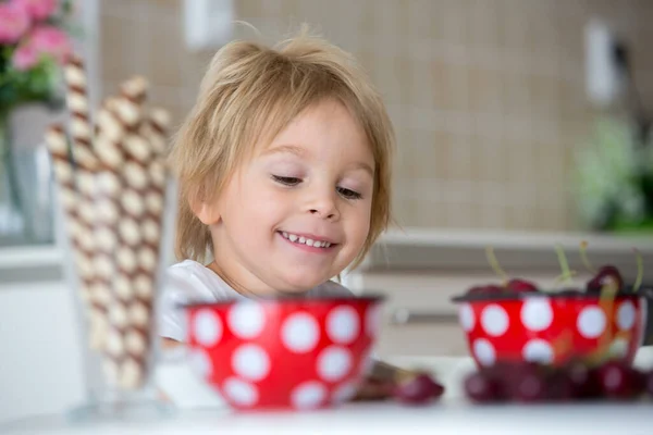 可爱的金发孩子 蹒跚学步的男孩 在家里吃樱桃 玩得开心 — 图库照片