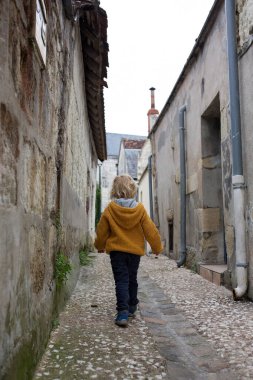 Çocuk, çocuk bulutlu bir günde Fransa 'nın güzel küçük bir köyünde yürüyor.