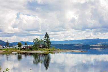 Norveç 'te güzel bir pelerin, fiyortlu harika İskandinav doğası, küçük kırmızı kulübeler ve güzel dağlar.