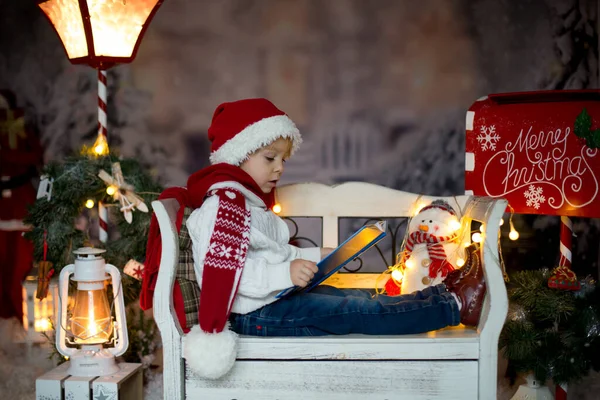 Красивый Ребенок Блондин Мальчик Читает Книгу Сидит Скамейке Рождественским Украшением — стоковое фото