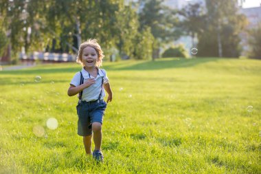 Gün batımında parkta oynayan sevimli anaokulu çocuğu.