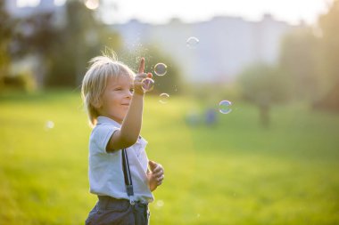 Gün batımında parkta oynayan sevimli anaokulu çocuğu.