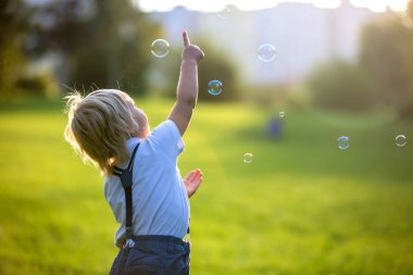 Gün batımında parkta oynayan sevimli anaokulu çocuğu.