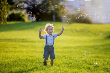 Gün batımında parkta oynayan sevimli anaokulu çocuğu.