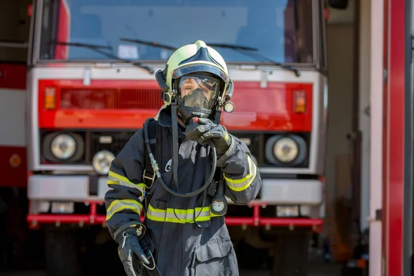 Child, cute boy, dressed in fire fighers cloths in a fire station with fire truck, childs dream