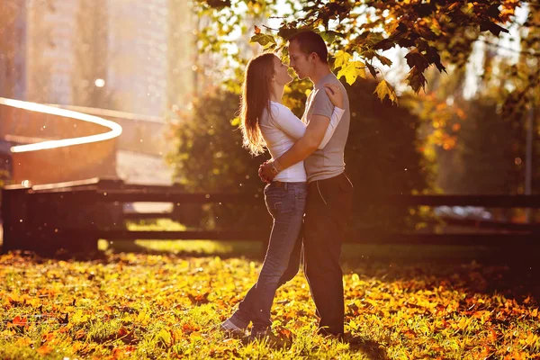 Jovem casal apaixonado, abraçando no pôr do sol no parque — Fotografia de Stock