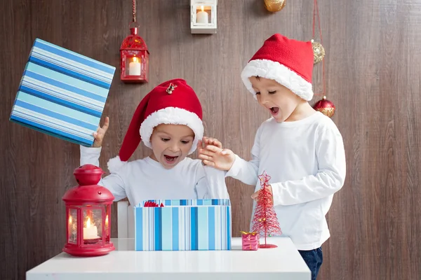 Dos adorables chicos, abriendo regalos en Navidad —  Fotos de Stock