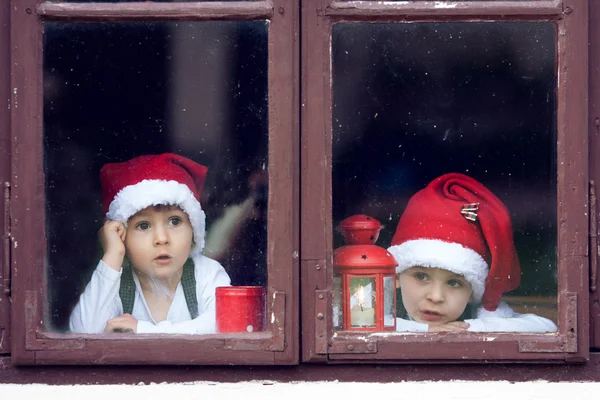 Dva roztomilý kluci, pohledu přes okno, čekání na Santa — Stock fotografie