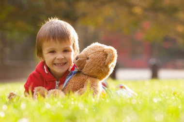 Sevimli küçük çocuk parkta oyuncak ayı ile