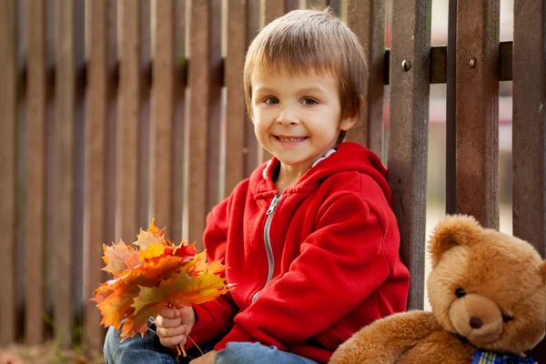 Adorable niño con osito de peluche en el parque — Foto de Stock